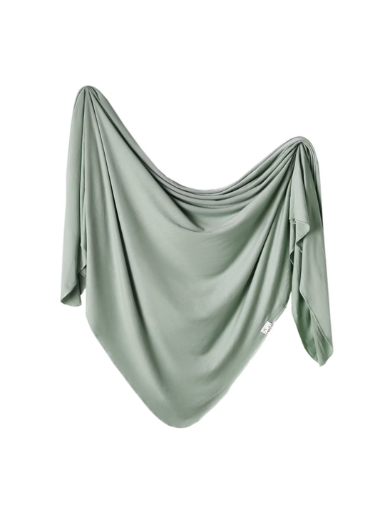 Soft sage green knit swaddle blanket draped with flowing folds