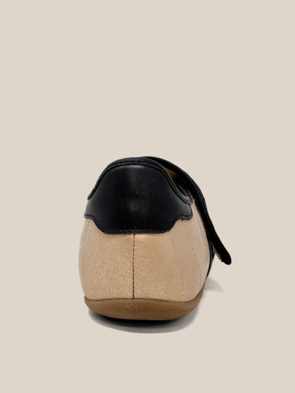 Gold and black leather flat sneaker rear view with velcro strap and rubber sole