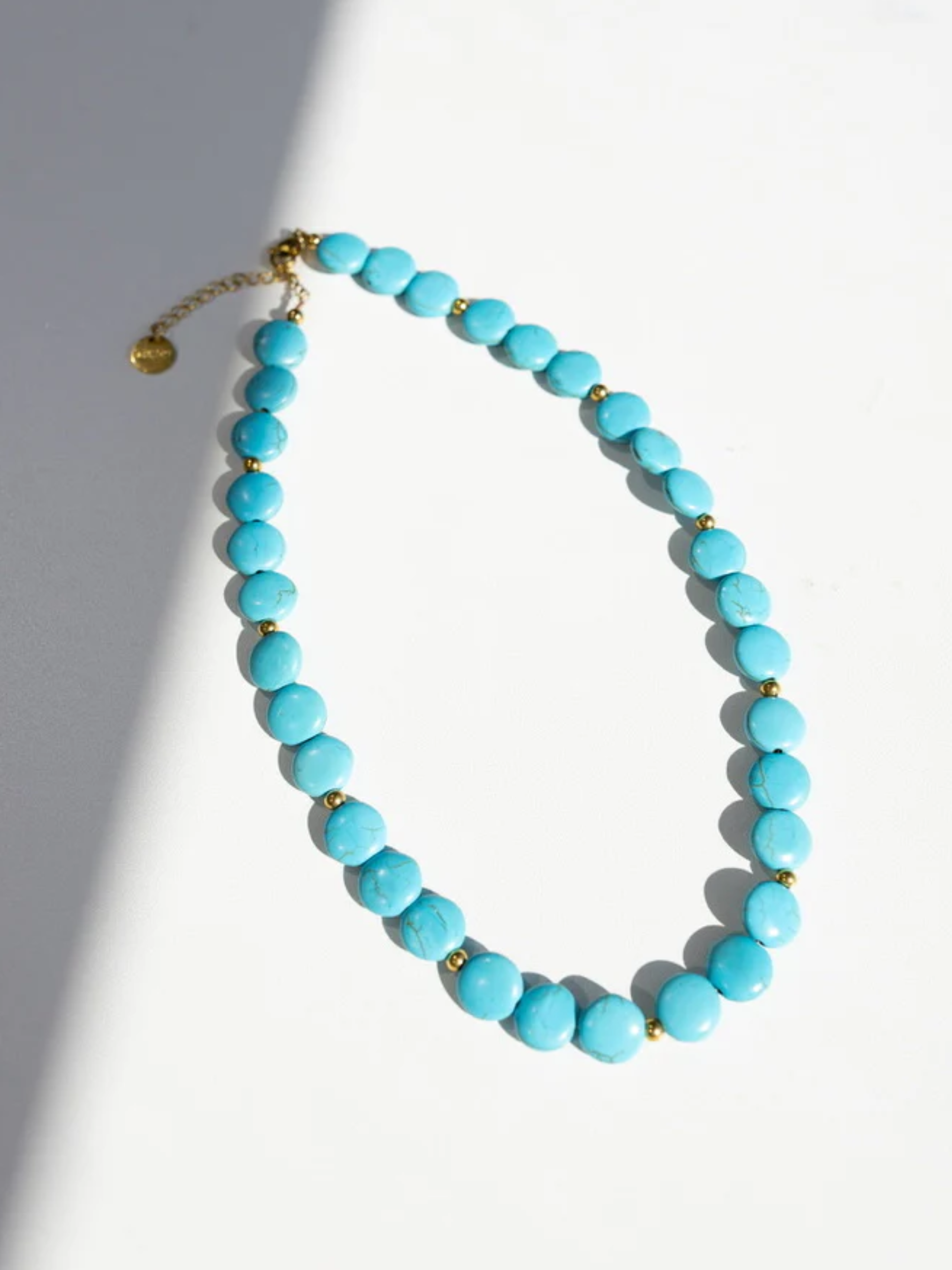 Turquoise coin bead necklace with small gold accent beads and adjustable chain clasp