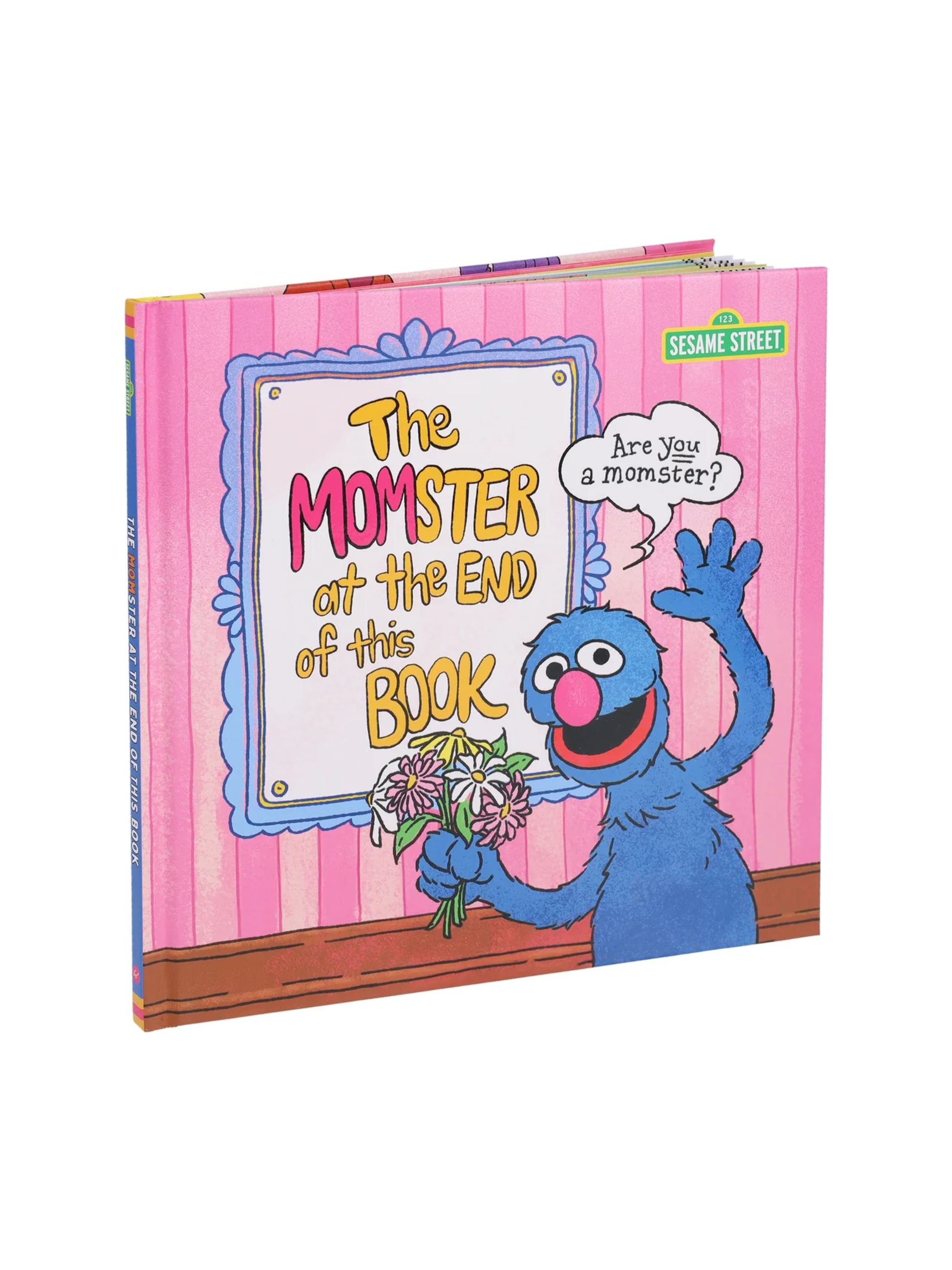 Pink hardcover children's book featuring a blue monster holding flowers