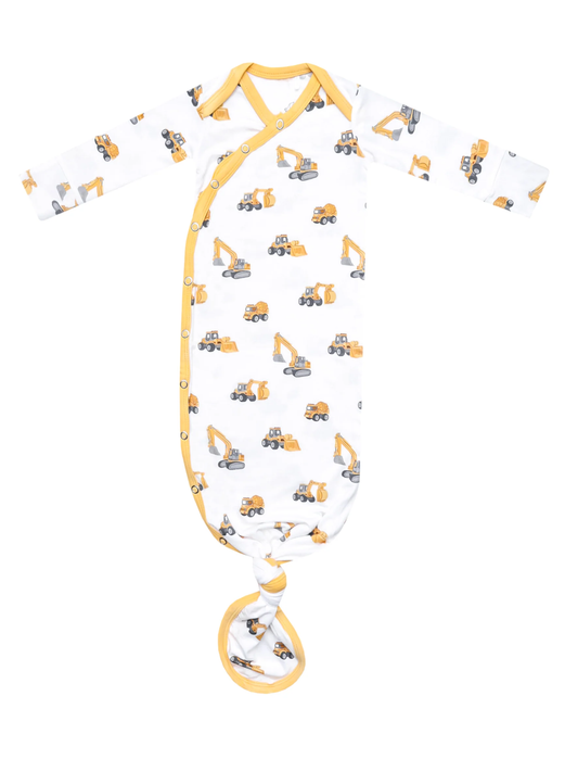 White knotted newborn gown with yellow construction vehicle print and snap closure