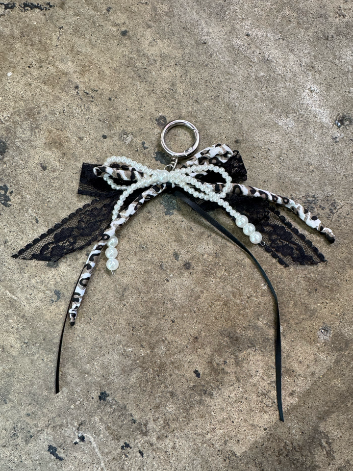 bow keychain with pearl bow, black ribbon bow, tulle ribbon bow, and a grey fabric leopard bow