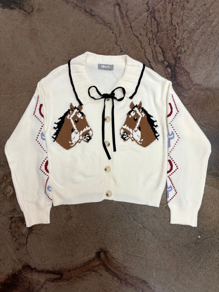 Front button cardigan with horse heads, has collar and black velvet bow at the neck