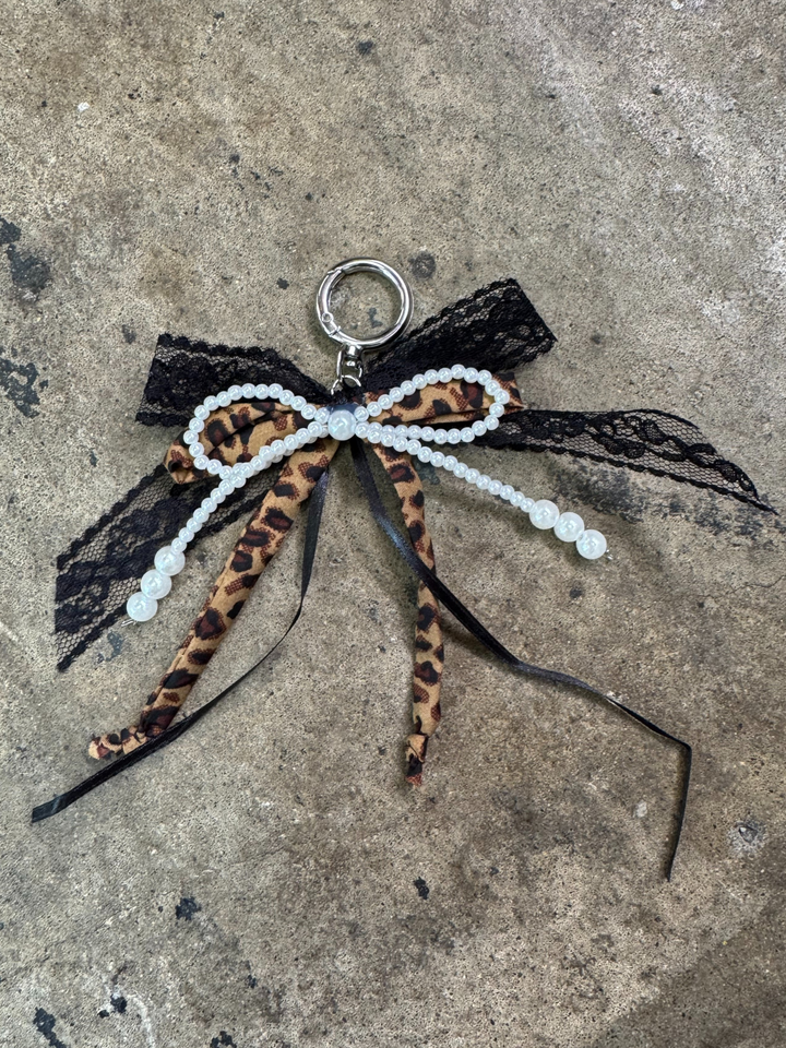 bow keychain with pearl bow, black ribbon bow, tulle ribbon bow, and a brown fabric leopard bow