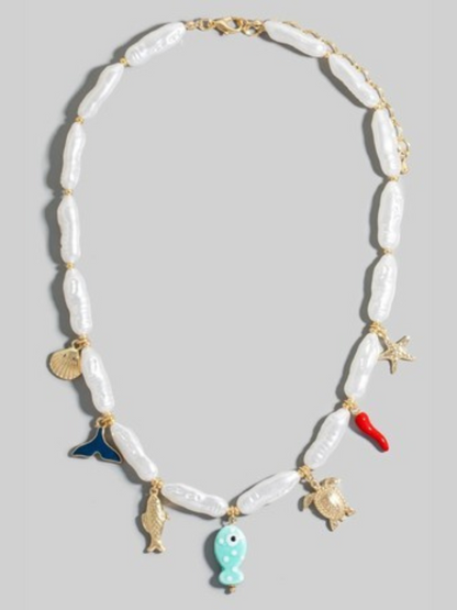 Necklace with shell beads and various charms on a light gray background