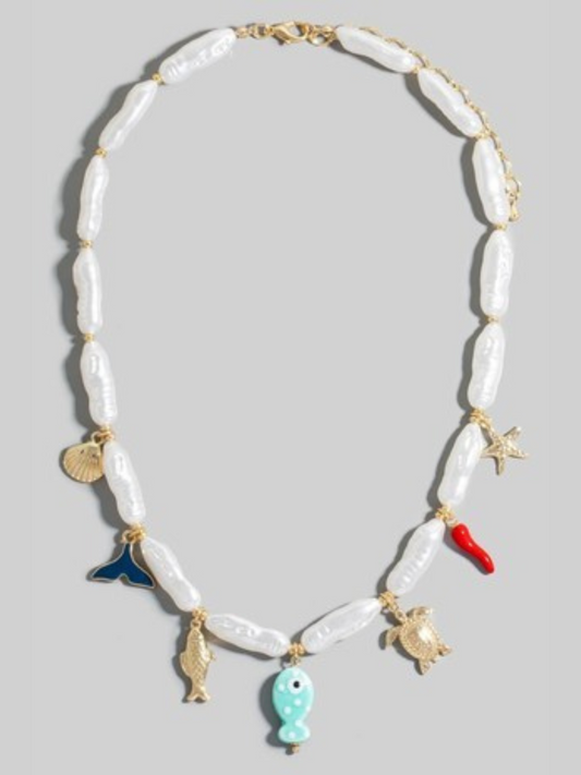 Necklace with shell beads and various charms on a light gray background