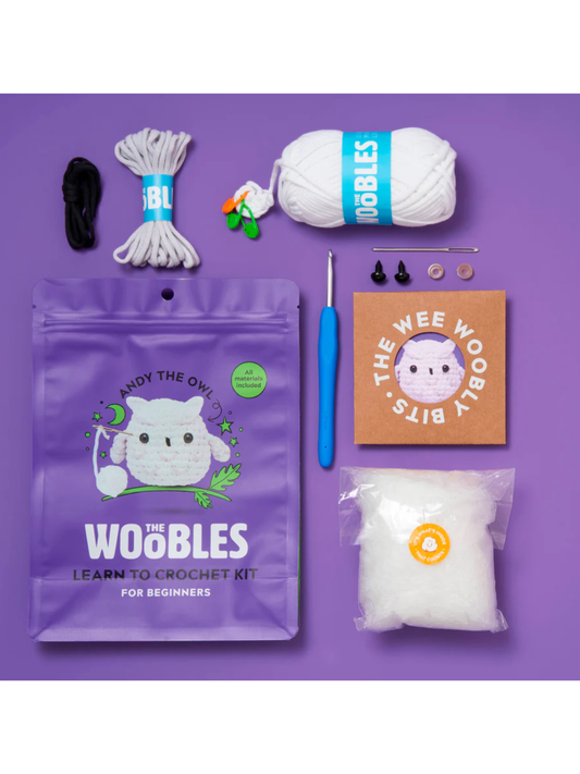 Beginner crochet kit with white yarn, blue hook, stuffing, safety eyes, and purple packaging