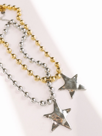 Silver and gold ball chain necklaces with silver star pendants on white background