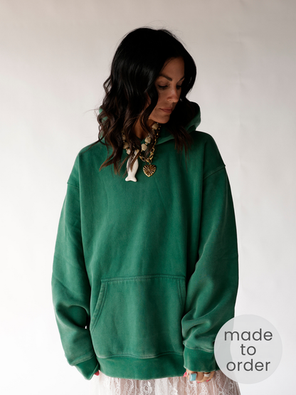 Oversized green pullover hoodie with front kangaroo pocket, worn relaxed fit
