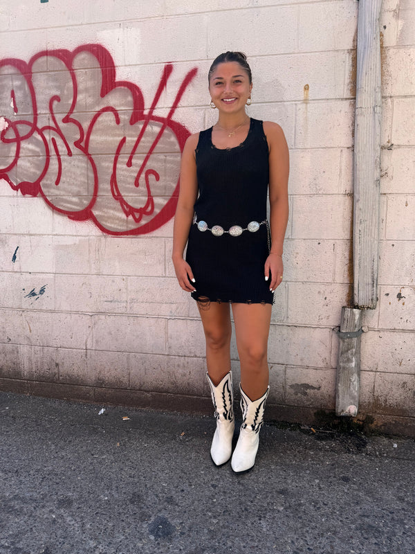 black mini dress, silver disc western belt, and white cowgirl boots outfit