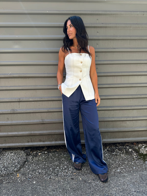 white longline vest and navy blue track pants